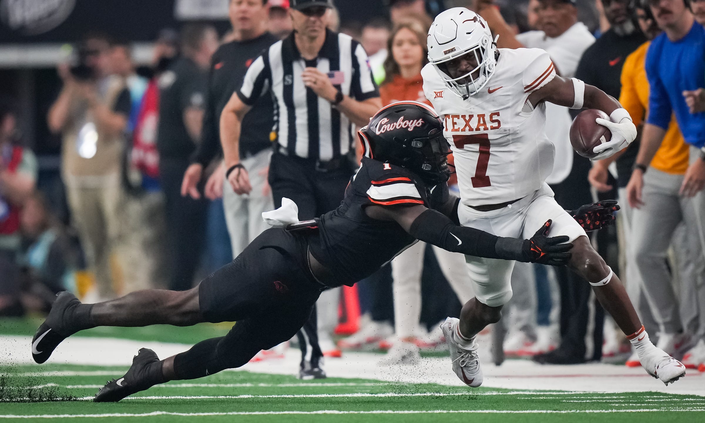 Oklahoma State linebacker Xavier Benson (1) dives to tackle Texas running back Keilan Robinson (7) in the first quarter of the Big 12 Conference Championship game at AT&T Stadium in Arlington, Texas, Saturday, Dec. 2, 2023